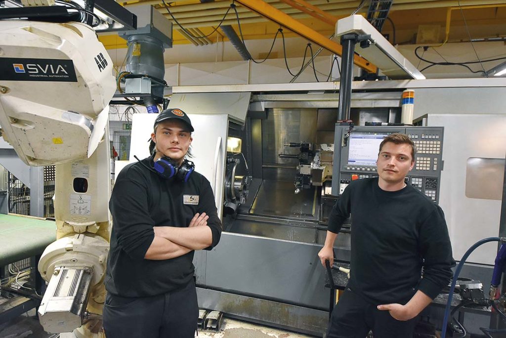 Maskinoperatörerna Alexander Högberg och Viktor Lindgren är framtiden på Bearbetningscenter. Här står grabbarna vid en av flera CNC-styrda flerfunktionsmaskiner från OKUMA med robotanslutning till maskin. 