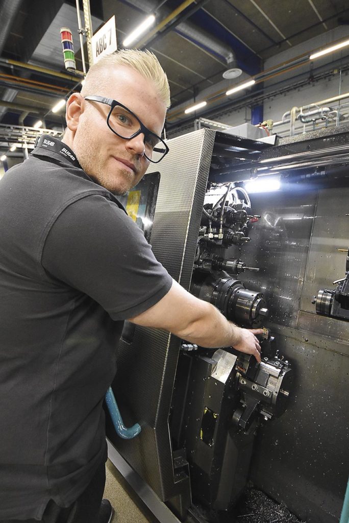 Alfred Jönsson, teknisk säljare på Fortiva, visar ett verktyg installerat i en av Bufab Lanns maskiner.